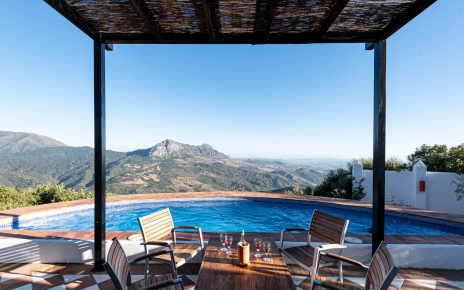 Zona de pérgola junto a la piscina para comidas al aire libre